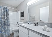 Thumbnail 7 of 15 - a bathroom with a shower toilet and sink