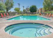 Thumbnail 5 of 20 - A hot tub sits in the middle of a pool surrounded by chairs.