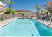 Thumbnail 19 of 20 - A swimming pool in a backyard with a fence around it.