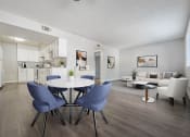 Thumbnail 8 of 20 - A modern kitchen with a dining table and chairs.