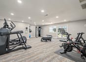 Thumbnail 35 of 35 - A spacious gym with a variety of exercise equipment including treadmills, stationary bikes, and a rowing machine.