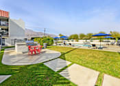 Thumbnail 30 of 42 - A sunny day at a poolside with a red table and chairs.