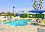 Thumbnail 28 of 42 - A blue umbrella is next to a pool.