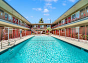 Thumbnail 2 of 17 - A long rectangular pool in a building with red railings.
