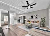 Thumbnail 5 of 17 - A living room with a white couch and a coffee table.