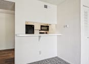 Thumbnail 10 of 110 - A white kitchen with a microwave and oven built into the cabinetry.