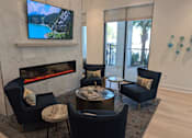 Thumbnail 19 of 30 - A living room with a fireplace and a television on the wall.