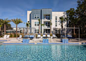 Thumbnail 18 of 30 - A modern building with a pool in front.