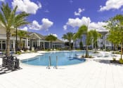 Thumbnail 22 of 29 - a large swimming pool in front of a building with palm trees