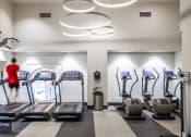 Thumbnail 15 of 28 - a woman running on the treadmill in a gym with cardio equipment
