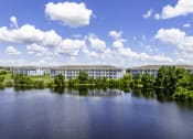Thumbnail 20 of 29 - an apartment building overlooking a lake on a sunny day
