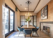 Thumbnail 19 of 31 - a dining room with a wooden table and chairs and a fireplace