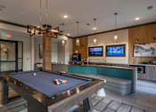 Thumbnail 25 of 31 - a pool table in a clubhouse with a bar and tv