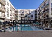 Thumbnail 9 of 31 - an apartment swimming pool in front of an apartment building