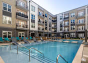 Thumbnail 8 of 31 - a swimming pool in front of an apartment building