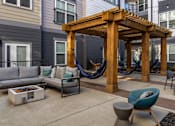 Thumbnail 11 of 31 - a patio with hammocks and couches in front of a house