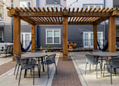 Thumbnail 12 of 31 - a patio with tables and chairs and a wooden pergola