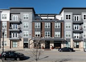 Thumbnail 29 of 31 - an apartment building on the corner of a street with cars