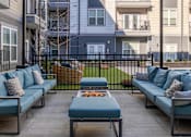 Thumbnail 13 of 31 - an outdoor patio with blue couches and a fire pit