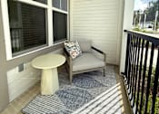 Thumbnail 30 of 30 - A small balcony with a white table and a sofa.