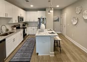 Thumbnail 26 of 30 - A modern kitchen with white cabinets and a center island.