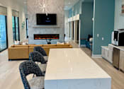 Thumbnail 20 of 30 - A modern kitchen with a white marble island and a television mounted above it.