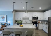 Thumbnail 7 of 29 - a kitchen with white cabinets and a marble counter top