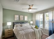 Thumbnail 9 of 29 - a bedroom with a large bed and a ceiling fan