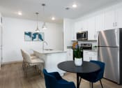 Thumbnail 16 of 92 - a kitchen and dining area with stainless steel appliances and a table and chairs