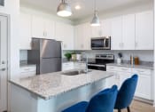 Thumbnail 6 of 92 - a kitchen with white cabinets and a granite counter top