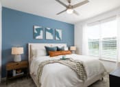 Thumbnail 21 of 92 - a bedroom with a large bed and a ceiling fan