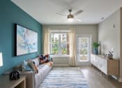 Thumbnail 6 of 29 - a living room with a couch and a ceiling fan