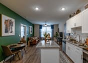 Thumbnail 2 of 31 - a kitchen and living room with green walls and white cabinets