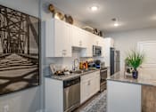 Thumbnail 1 of 31 - a kitchen with white cabinets and stainless steel appliances and a counter top