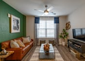 Thumbnail 4 of 31 - a living room with green walls and a brown leather couch