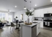 Thumbnail 11 of 29 - a kitchen and living room with white cabinets and a counter top