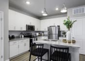 Thumbnail 2 of 29 - an open kitchen with white cabinets and a granite counter top