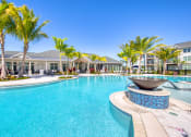 Thumbnail 19 of 54 - a large swimming pool with palm trees and a building in the background