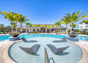 Thumbnail 23 of 54 - a swimming pool with chairs and palm trees in front of a hotel