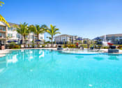 Thumbnail 21 of 54 - a large swimming pool with palm trees and buildings in the background
