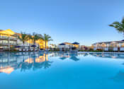Thumbnail 16 of 54 - a large swimming pool with palm trees next to a resort