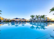 Thumbnail 17 of 54 - a large swimming pool with palm trees and buildings around it