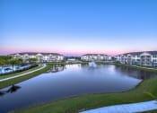 Thumbnail 5 of 54 - a fountain in the middle of a pond with houses around it