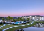 Thumbnail 1 of 54 - a large building with a pool and a lake at dusk