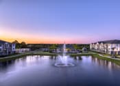Thumbnail 8 of 54 - a fountain in the middle of a pond at sunset