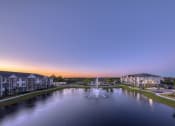 Thumbnail 2 of 54 - a fountain in the middle of a pond with houses around it