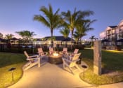 Thumbnail 14 of 54 - a patio with chairs and a fire pit at night
