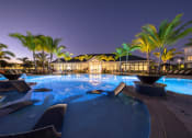 Thumbnail 3 of 54 - a large swimming pool at night with palm trees