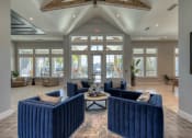 Thumbnail 38 of 54 - a large lobby with blue couches and chairs and windows