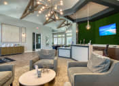 Thumbnail 33 of 54 - a lobby with couches and chairs and a reception area with a tv